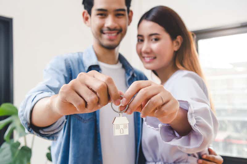 Young couple holding keys to their new home