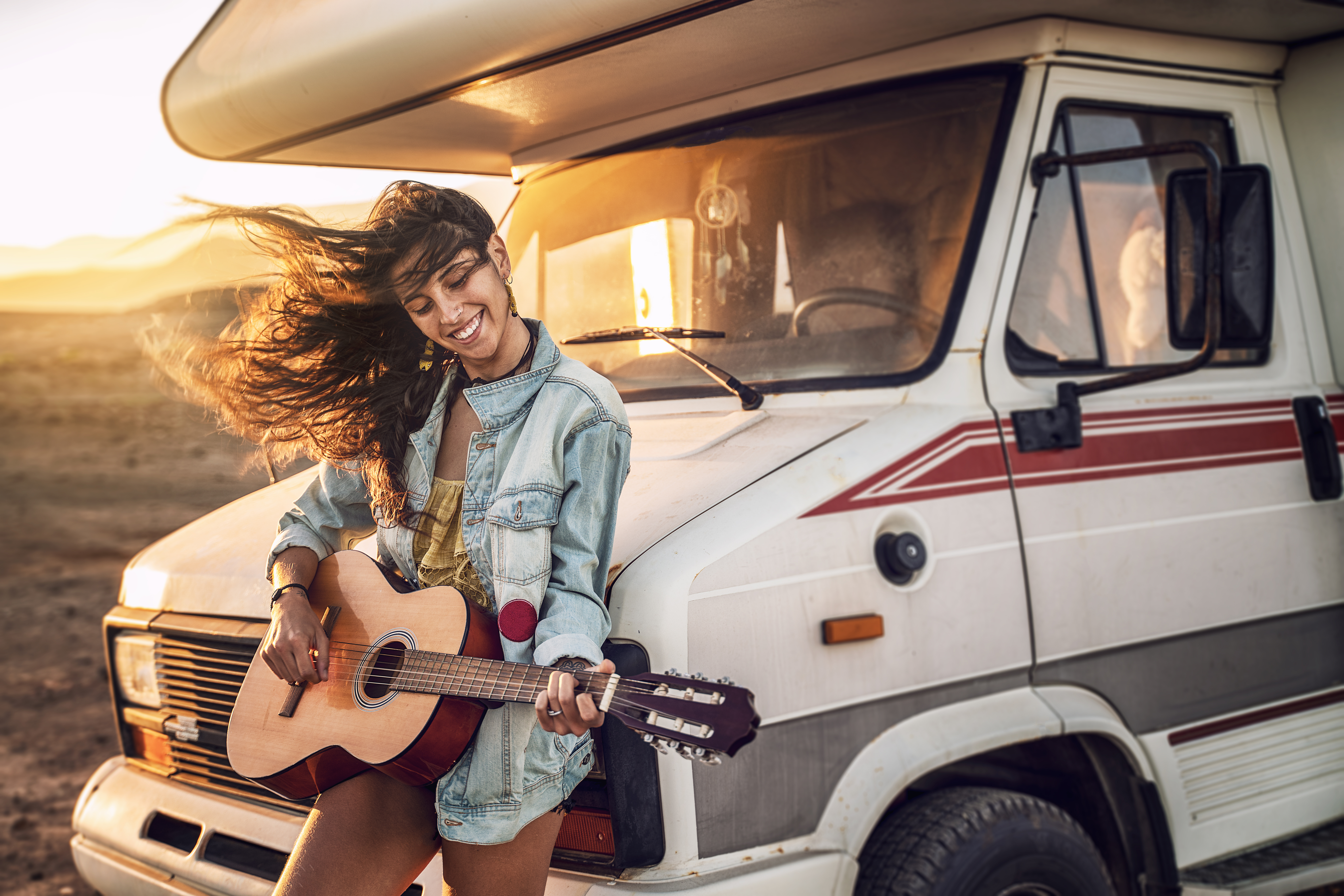 Girl playing guitar to her RV