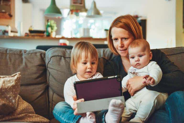 Mom with two young kids teaching financial literacy on the Family Roo website