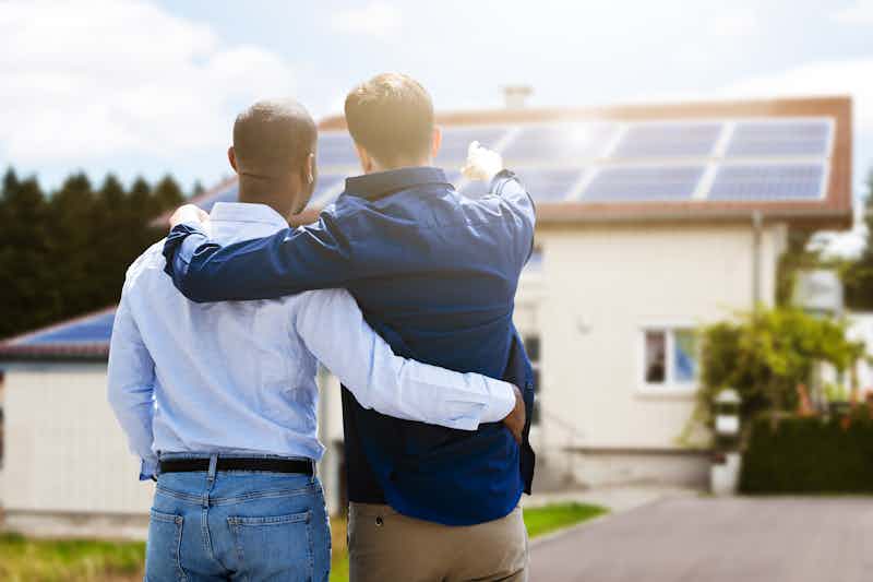 gay couple looking in awe at their solar panels they bought with their class act solar loan about to save so much money