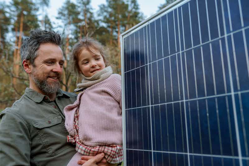 Dad and daughter holding a solar panel