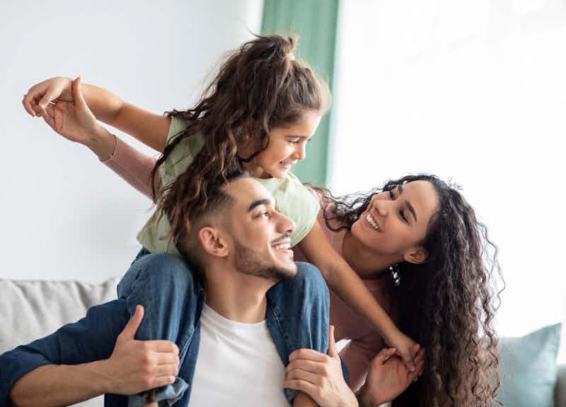 Family With Little Girl On Mans Shoulders